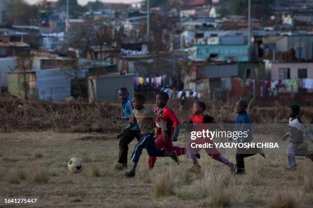 Children play football in Soweto on June 12, 2009 two days ahead of the opening match of the FIFA Confederations Cup in Johannesburg. A visit by...