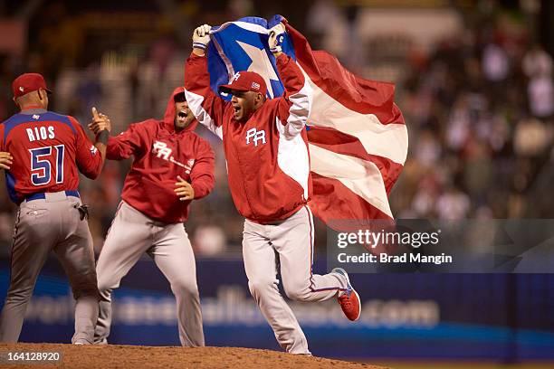 World Baseball Classic: Team Puerto Rico Hiram Burgos victorious on field with flag after winning Semifinals game vs Team Japan at AT&T Park....