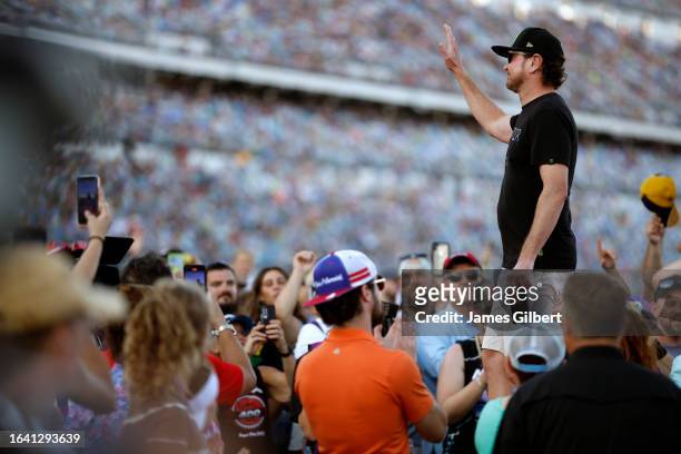 Cup Series driver, Kurt Busch waves to fans as he walks onstage during driver intro after the announcement of his retirement prior to the NASCAR Cup...