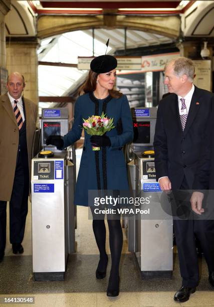 Catherine, Duchess of Cambridge walks through a ticket barrier as she makes an official visit to Baker Street Underground Station, to mark 150th...