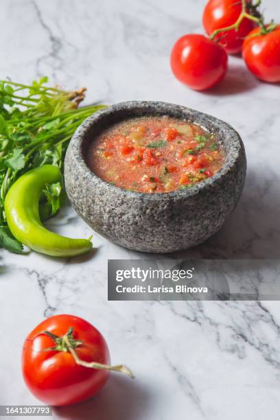 traditional latin american mexican tomato sauce salsa, chilean chancho en piedra in stone mortar. - chancho stockfoto's en -beelden