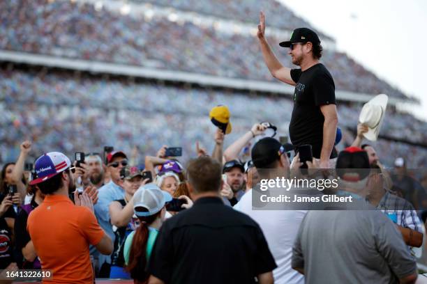 Cup Series driver, Kurt Busch waves to fans as he walks onstage during driver intro after the announcement of his retirement prior to the NASCAR Cup...