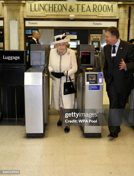 Queen Elizabeth II walks through a ticket barrier as she makes an official visit to Baker Street Underground Station, to mark 150th anniversary of...