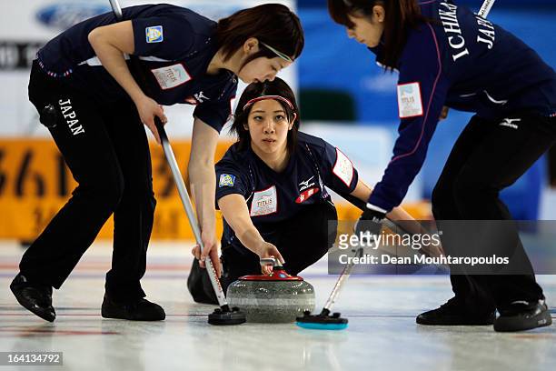 Emi Shimizu of Japan throws the stone as Miyo Ichikawa and Chiaki Matsumura sweep in the match between Japan and Russia on Day 5 of the Titlis...