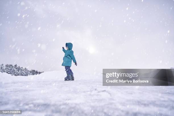 a child learns to skate on a makeshift ice rink on the lake. - figure skating child stock pictures, royalty-free photos & images