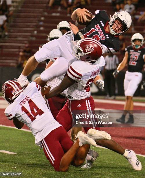 Safety Dashaun Jerkins and linebacker Gerrell Johnson of the Massachusetts Minutemen tackle quarterback Diego Pavia of the New Mexico State Aggies as...