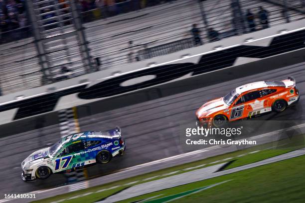 Chris Buescher, driver of the Fifth Third Bank Ford, crosses the finish line ahead of Brad Keselowski, driver of the King's Hawaiian Ford, to win the...
