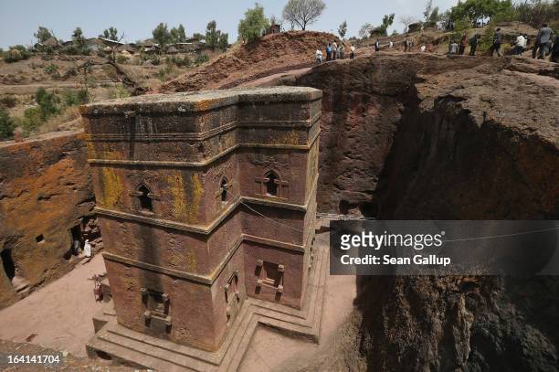 Visitors walk past Bete Giyorgis, also called St. George's Church, at the Lalibela holy sites on March 19, 2013 in Lalibela, Ethiopia. Lalibela is...