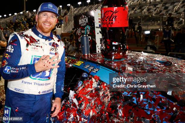 Chris Buescher, driver of the Fifth Third Bank Ford, poses next to his winner sticker in victory lane after winning the NASCAR Cup Series Coke Zero...