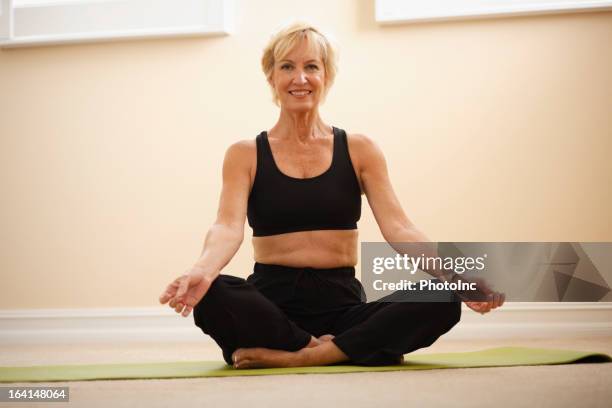 mujer mayor practicar yoga - malla de gimnasia fotografías e imágenes de stock
