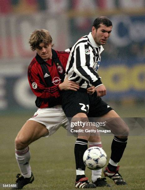 Zinedine Zidane of Juventus holds off Thomas Helveg of AC Milan during the Italian Serie A match at the San Siro Stadium in Milan, Italy. The game...