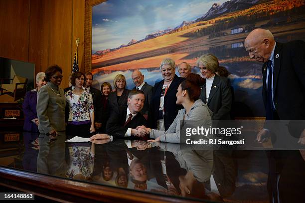Colorado Governor John Hickenlooper shacks the hand of Karina Vargas, right, who was paralyzed from a shooting outside Aurora Central High School,...