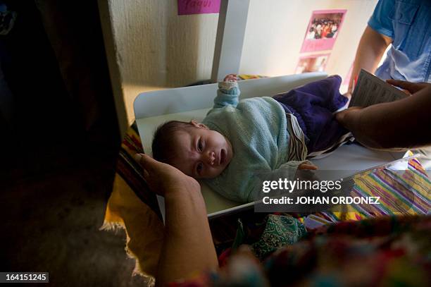 Nurse weighs a baby in a community home during visit of Tony Lake , Executive Director of the United Nations Children's Fund , during a visit to the...