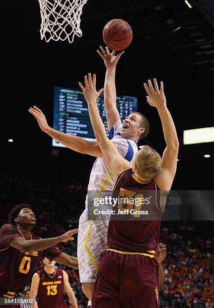 Travis Wear of the UCLA Bruins shoots over Jonathan Gilling of the Arizona State Sun Devils during the quarterfinals of the Pac 12 Basketball...