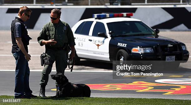 Greg Biffle, driver of the 3M Ford Fusion, participates in a narcotic detection exercise with Fort Worth Police officer Harald Cussnick and Kelev, a...