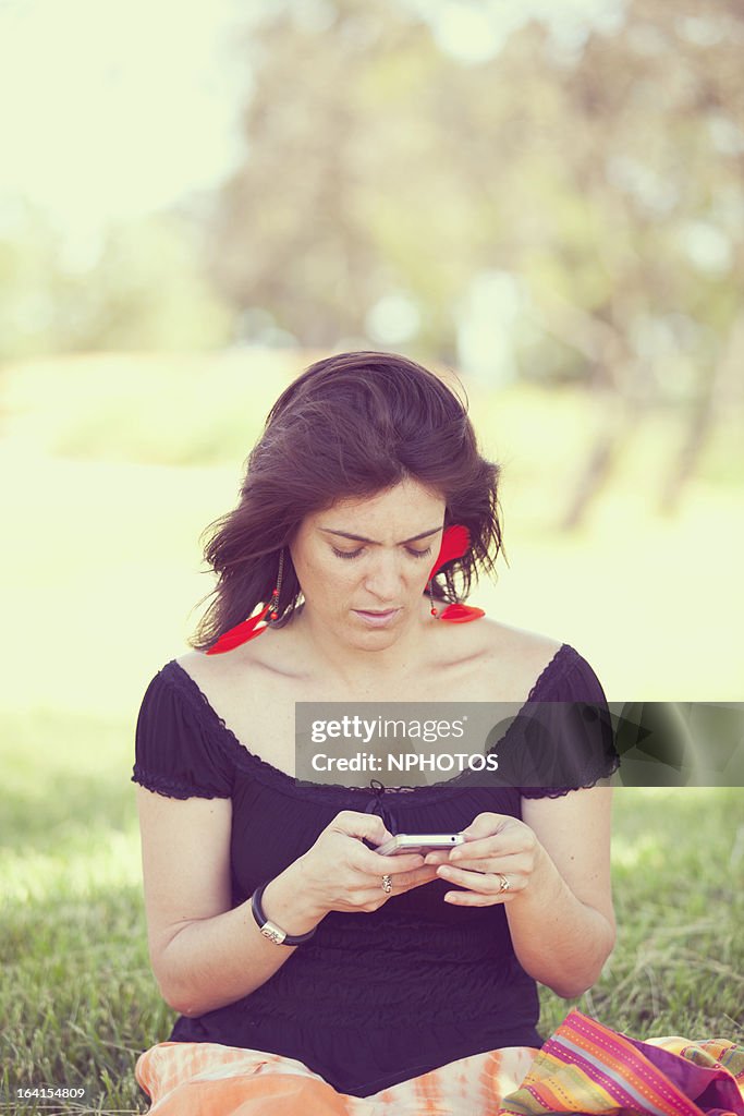 Woman reading text message outdoors