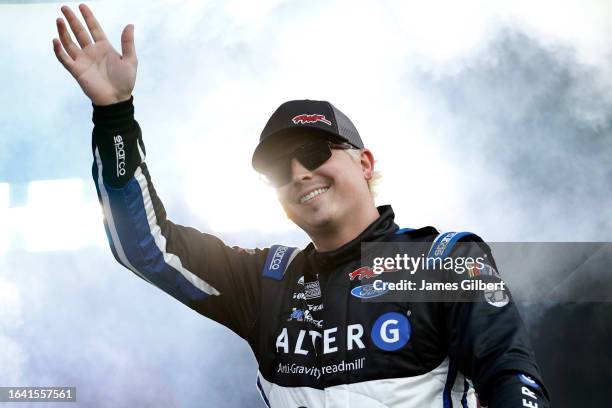 Brennan Poole, driver of the Finance Pro Plus Ford, waves to fans as he walks onstage during driver intros prior to the NASCAR Cup Series Coke Zero...