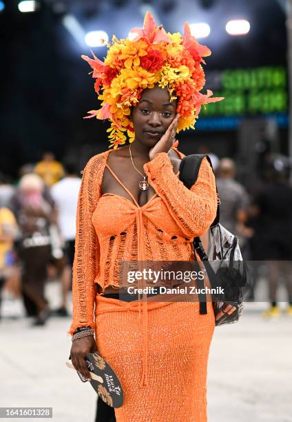 Kayla Dike is seen wearing an orange Fashion Nova outfit with a floral headpiece during the 2023 Afropunk festival at Greenpoint Terminal on August...