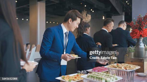 asian seminar participants picking up food in business conference meeting coffee break - indian buffet stock pictures, royalty-free photos & images