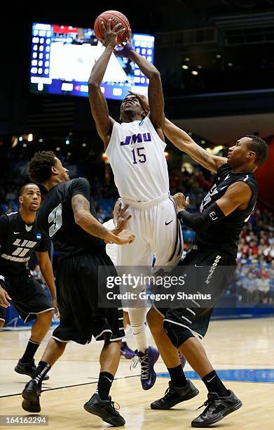 Andre Nation of the James Madison Dukes goes up for a shot between C.J. Garner and E.J. Reed of the LIU Brooklyn Blackbirds in the first half of...