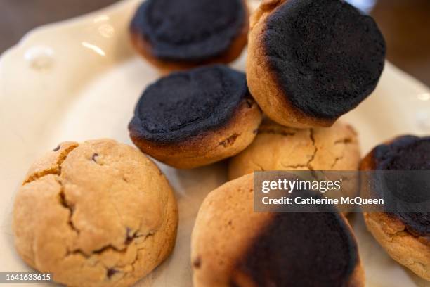 plate of burnt homemade chocolate chip cookies - burnt cookies stock pictures, royalty-free photos & images