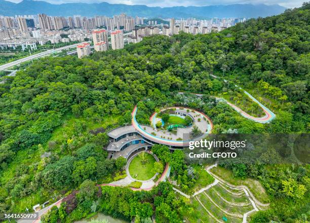 People walk along the city's Rainbow Walk into the green mountains in Fushan Country Park, Gulou District, Fuzhou, Fujian province, China, September...