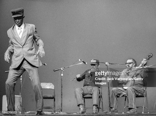 American Piedmont Blues musician John Dee Holeman dances , accompanied by cousins Joe Thompson on fiddle and Odell Thompson on banjo, during a...