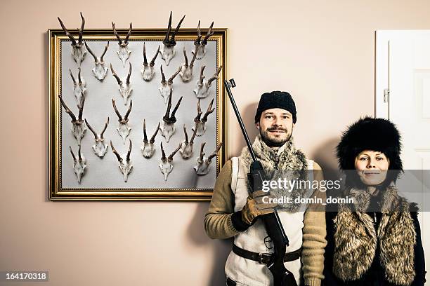 funny portrait of content hunter and his wife with shotgun - hunting trophy stock pictures, royalty-free photos & images