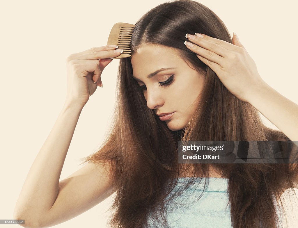 Young brunette Frau Kämmen ihre schönen langen Haare