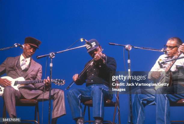 American Piedmont Blues musician John Dee Holeman plays guitar, accompanied by cousins Joe Thompson on fiddle and Odell Thompson on banjo, during a...