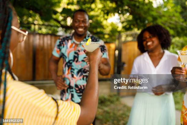 young woman raising a toast with her margarita cocktail during a garden party - summer cocktails garden party drinks bildbanksfoton och bilder