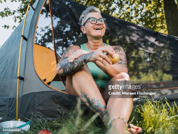 frau sitting in tent eating an apple - tattoo frau stock pictures, royalty-free photos & images