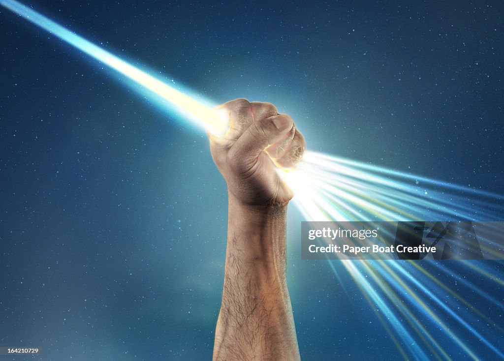 Hand holding light laser beam that bursts out