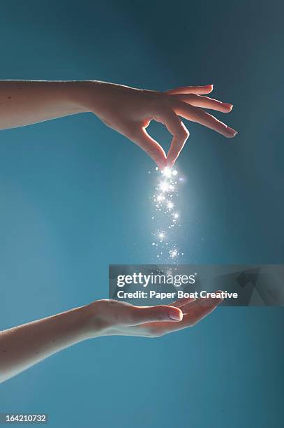 hand sprinkling light sparkles in studio - sprinkles stock-fotos und bilder