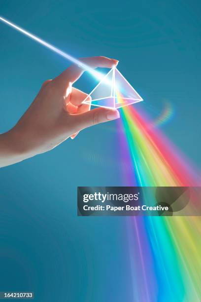 hand holding rainbow light prism in studio - prism light photos et images de collection