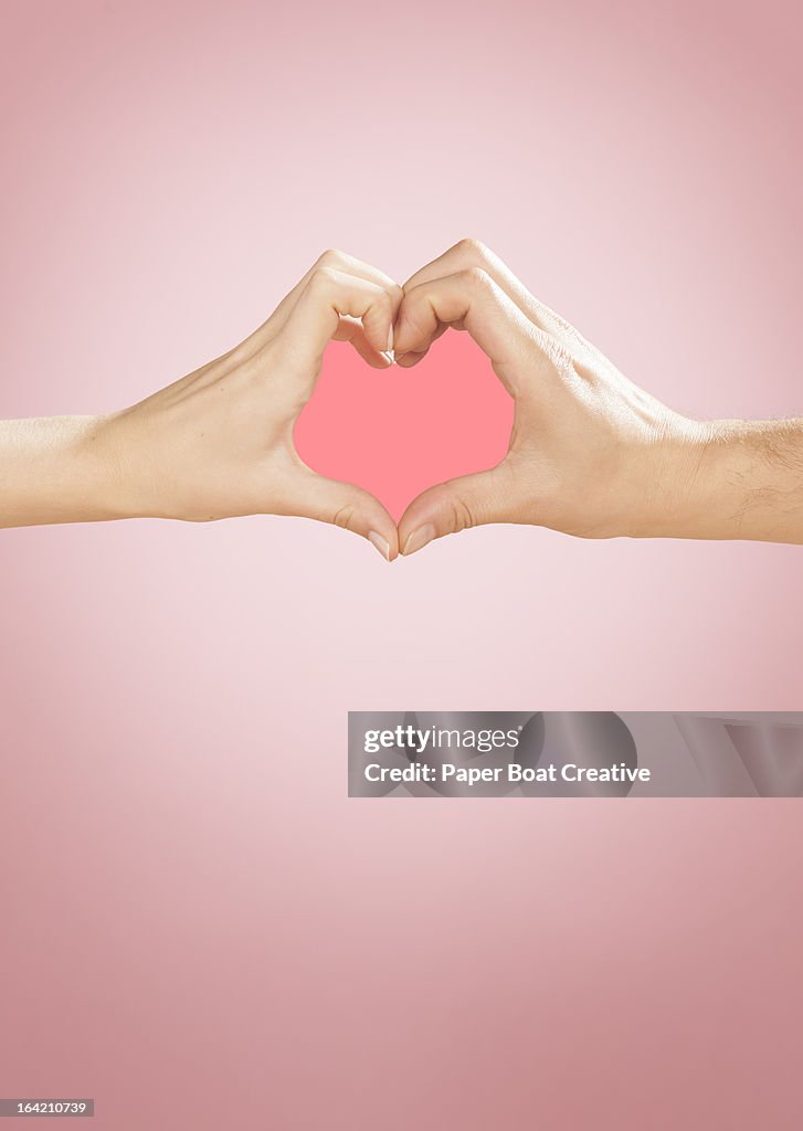 Hands making heart shape in studio