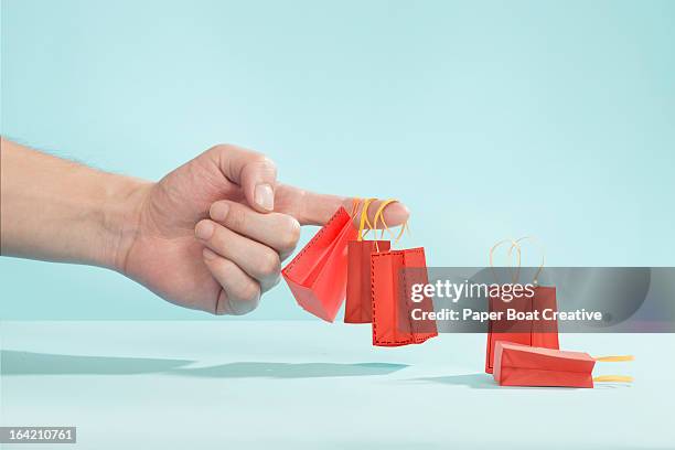 hand picking up tiny shopping bags on finger - tiny hands stock pictures, royalty-free photos & images