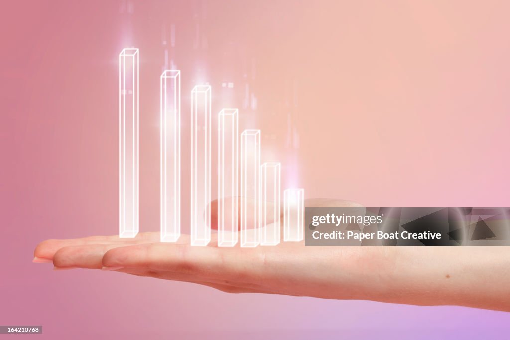 Chart resting on hand with pink studio background