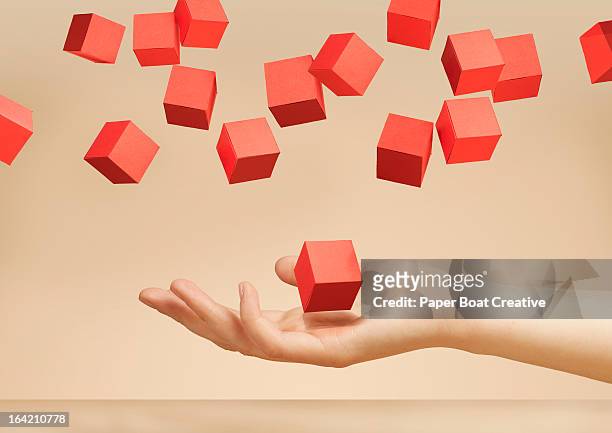 hand holding floating paper boxes in the studio - abundance stock pictures, royalty-free photos & images