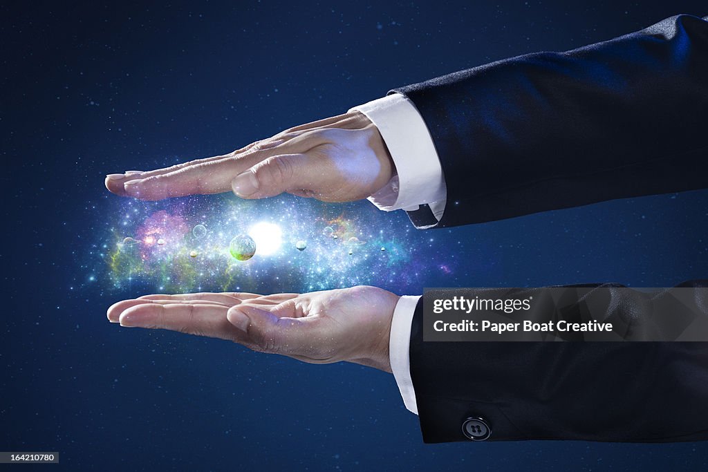 Close up of businessman's hand holding a galaxy