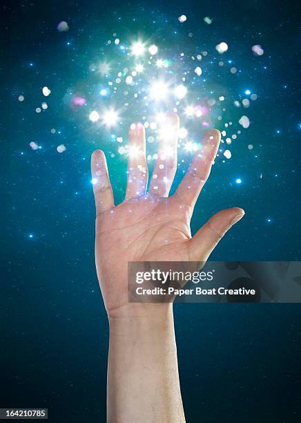 hand touching sparkles and abstract glow - zauberer darstellender künstler stock-fotos und bilder