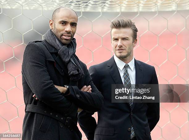 Frederic Kanoute of Beijing Guo'an stands with with British football player David Beckham during his visit to Beijing Guo'an Football Club at Workers...