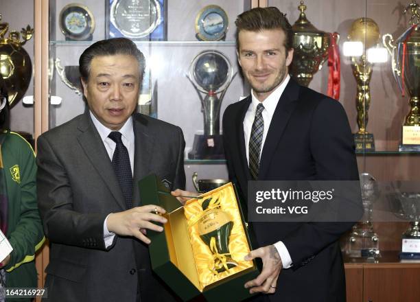 Bejing Guoan General Manager Gao Chao presents a gift to David Beckham at Workers Stadium on March 21, 2013 in Beijing, China.