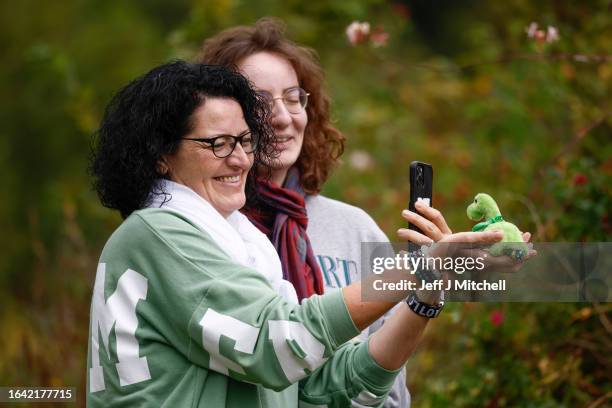 Tourists photograph a souvenir toy of the Loch Ness Monster as Nessie hunters search Loch Ness for what is being described as the biggest search for...