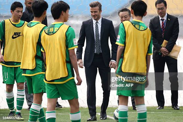 Football superstar David Beckham teaches young players during a visit to Beijing Guoan soccer club in Beijing on March 21, 2013. Beckham flew to...