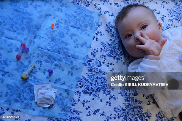 Semoyn Bledans, a child with Down syndrome, looks on while laying at home outside Moscow, on February 8, 2013. Russia marked today the International...