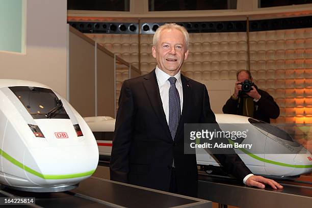 Ruediger Grube, chief executive officer of Deutsche Bahn, poses with models of InterCity Express high-speed trains prior to the company's full-year...
