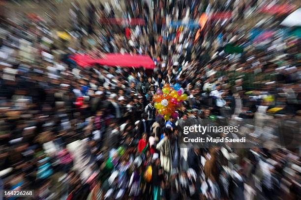 Balloon vendor stands amongst Afghan families as they gather near the Sakhi shrine, which is the centre of the Afghanistan new year celebrations...