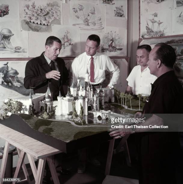 Walt Disney stands by a plan and model of Disneyland and chats with some imagineers circa 1954 in Los Angeles, California.