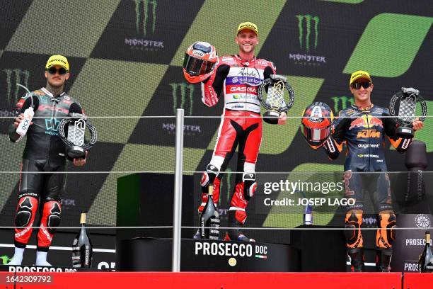 Kalex British rider Jake Dixon poses on the podium with Kalex Spanish rider Aron Canet and Kalex Spanish rider Albert Arenas after winning the Moto2...